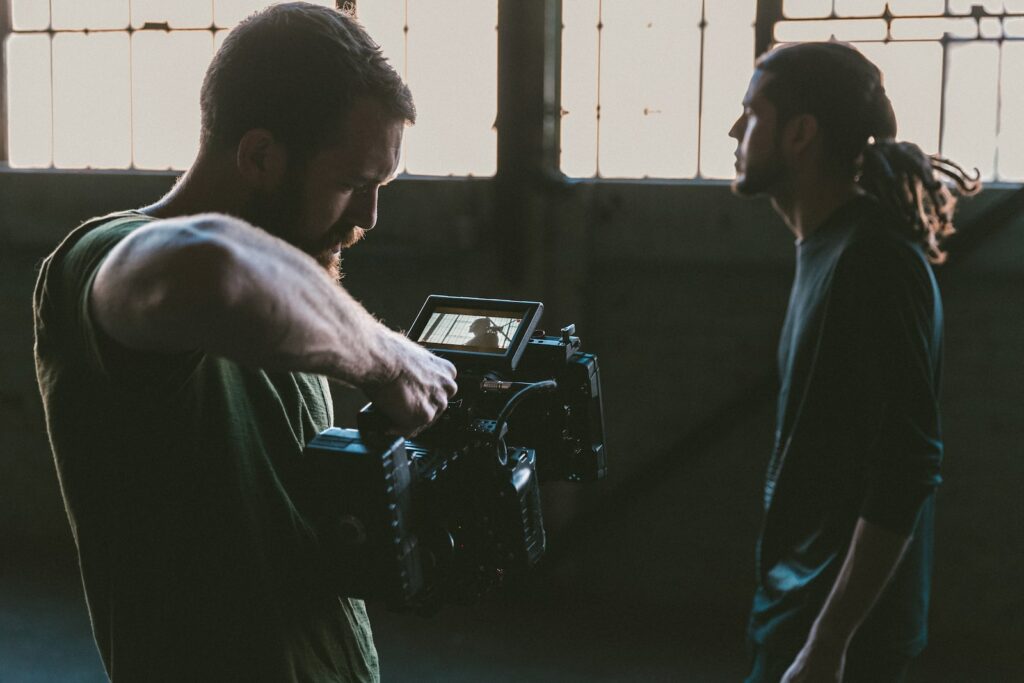 man holding camcorder with man looking away and looking uncomfortable, symbolising Stage Fright